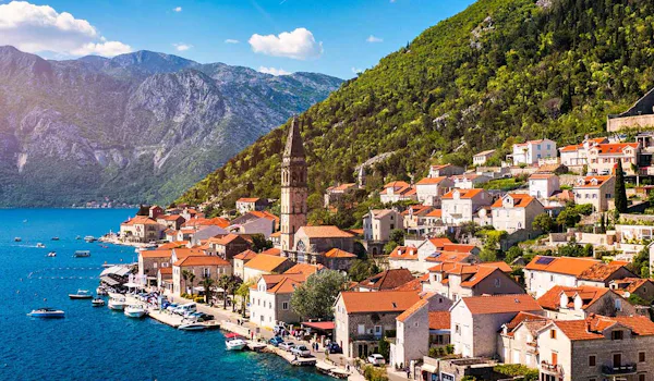 View of the historic town of Perast at famous Bay of Kotor on a beautiful sunny day with blue sky and clouds in summer, Montenegro. Historic city of Perast at Bay of Kotor in summer, Montenegro.